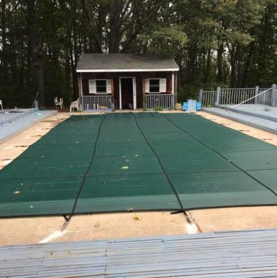 Green safety cover on inground pool