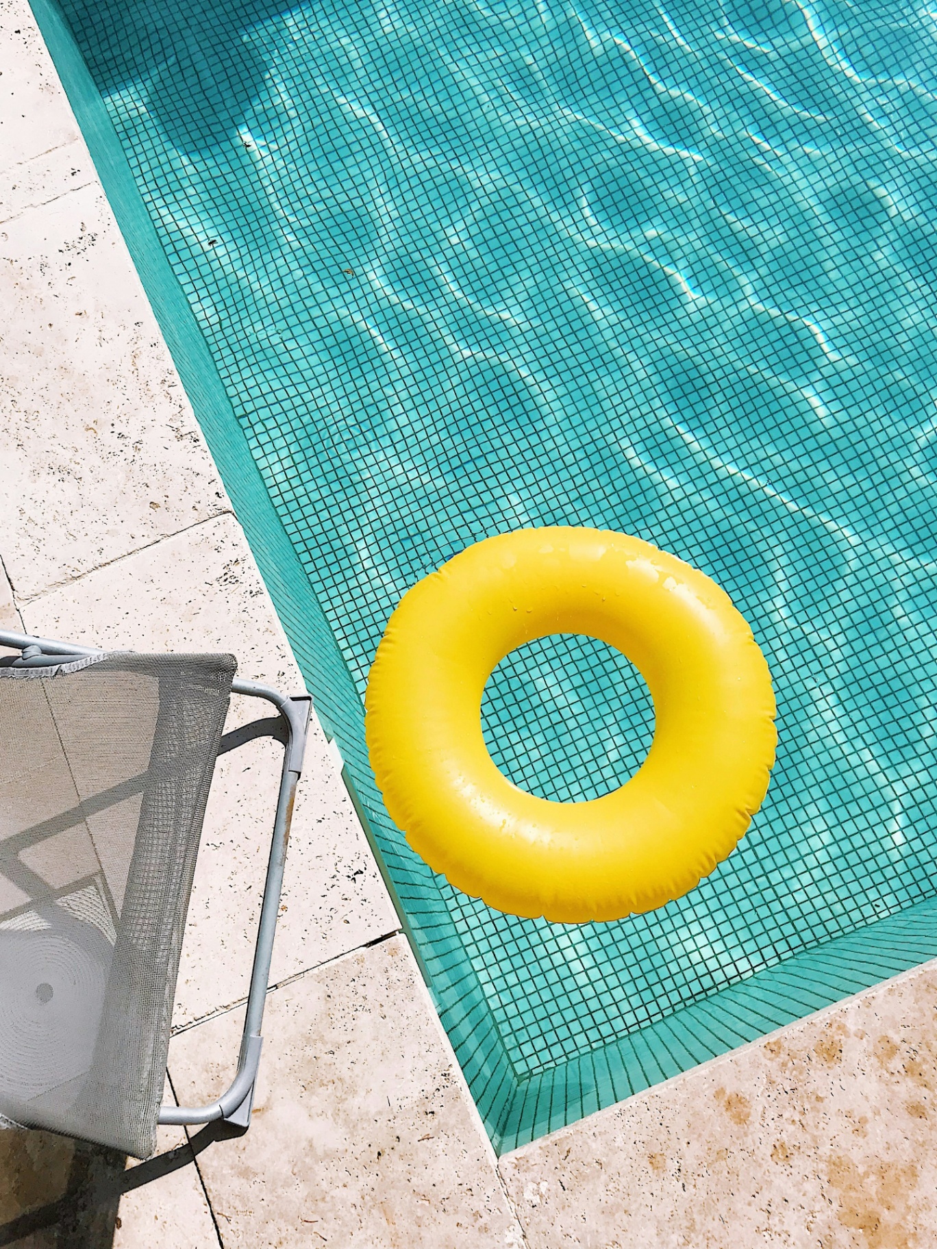 Yellow float drifting on calm pool water